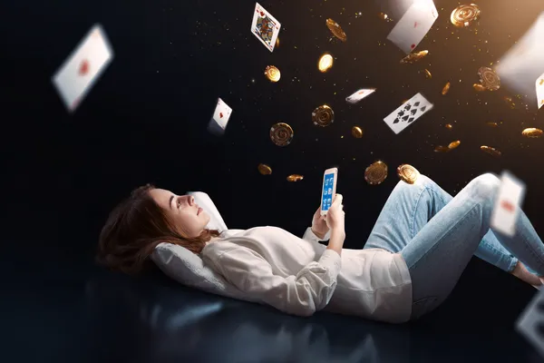 4777BAT App — Enjoy seamless gaming on your smartphone A young woman relaxing with her phone while dynamic casino elements float around her, illustrating the smooth mobile experience offered by the 4777BAT app.